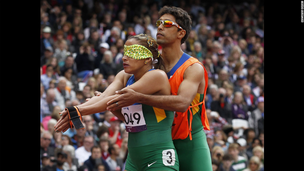 Brazil&#39;s Terezinha Guilhermina, left, prepares with her coach at the start of the women&#39;s 200-meter T11 race.
