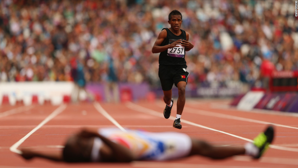 Filomeno Soares of East Timor competes in the men&#39;s 400-meter - T38 heats at Olympic Stadium. The winner, Venezuela&#39;s Omar Monterola, lies on the floor after crossing the finish line.