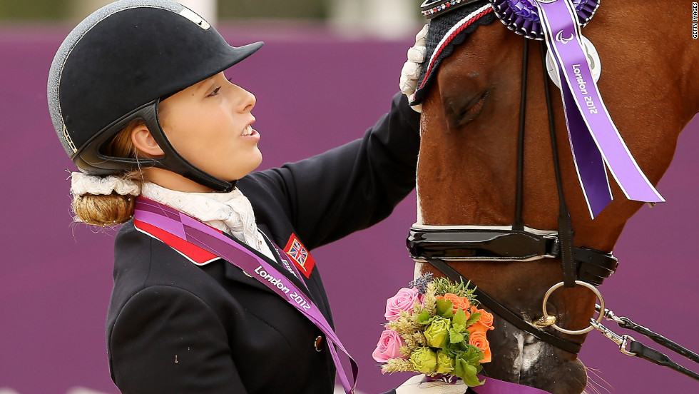 Sophie Wells of Great Britain caresses her horse Pinocchio after winning silver in the dressage individual championship test -Grade IV on Sunday.