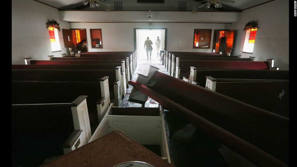 An insurance inspector tours the damaged Bethlehem Baptist Church on Tuesday.