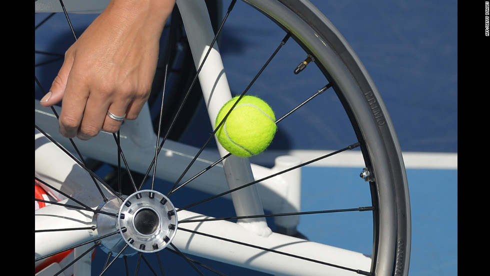 Netherlands&#39; Esther Vergeer keeps a spare ball in the spokes of her wheelchair as she plays Netherlands&#39; Aniek Van Koot in the women&#39;s singles wheelchair tennis final on Friday.