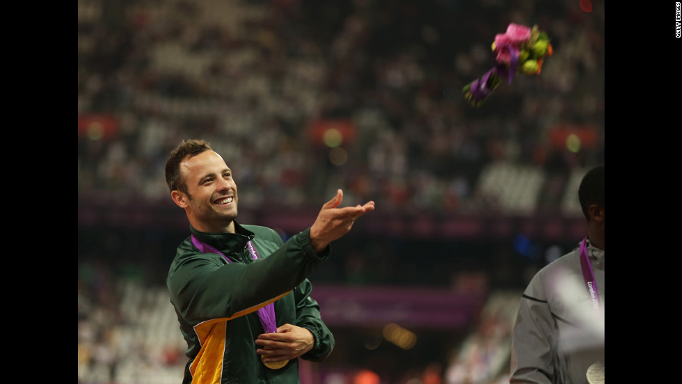 Gold medalist Oscar Pistorius of South Africa throws a bouquet of flowers on the podium during the medal ceremony for the men&#39;s 400-meter T44 final Saturday, September 8, at the 2012 Paralympic Games. 