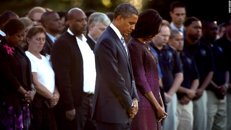 President Barack Obama and first lady Michelle Obama observe a moment of silence with White House staff on Monday.