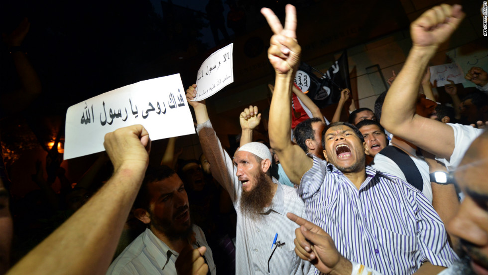 Egyptian riot police stand guard as protesters climb down from the wall. 