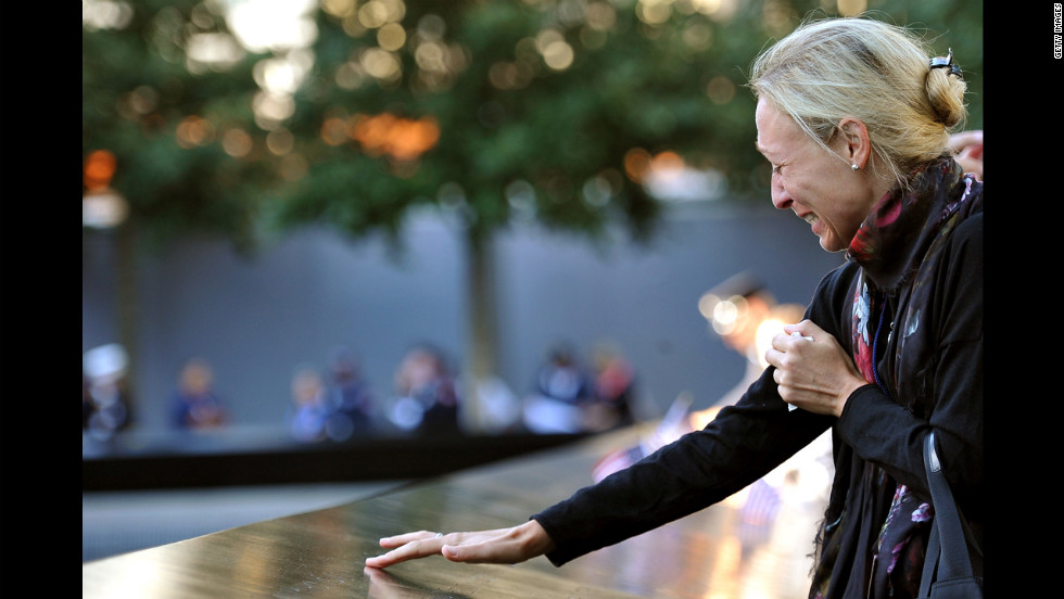 A woman cries as she stands over the reflecting pool at the World Trade Center site on Tuesday.