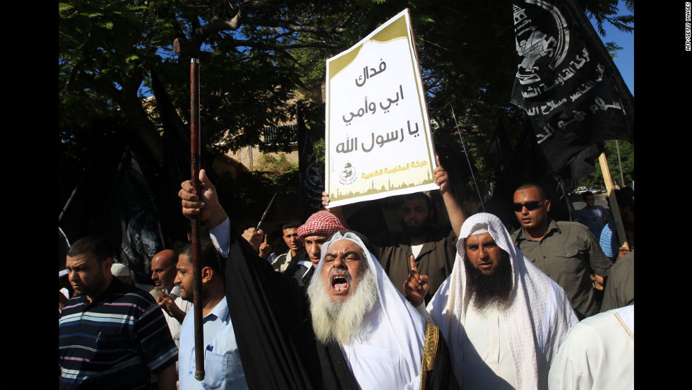 A Palestinian man holds a placard praising Islam&#39;s prophet Mohammed during a demonstration against the film on Wednesday in front of the United Nations headquarters in Gaza City.