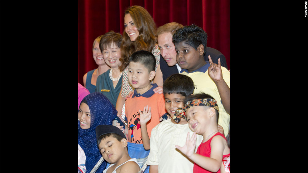 The duke and duchess pose for a picture with children as they visit The Rainbow Centre in Singapore. 