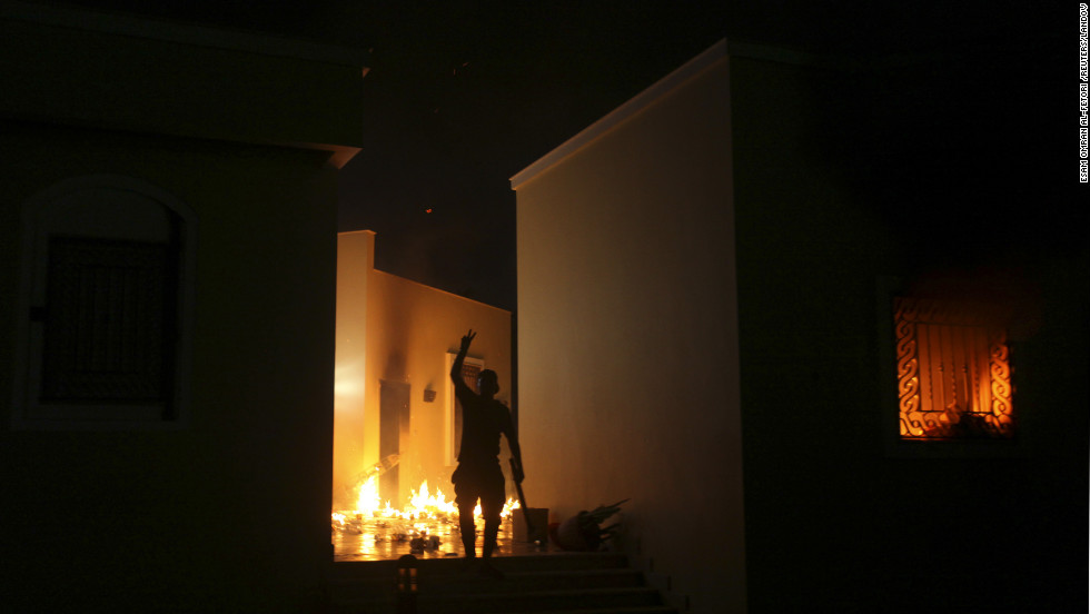 A protester reacts as the U.S. Consulate in Benghazi is seen in flames Tuesday night. 