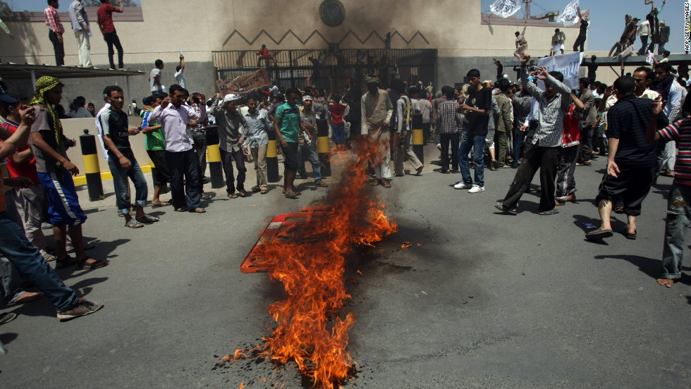 Yemeni protesters gather around a fire Thursday during a demonstration outside the U.S. Embassy in the capital of Sanaa.  Yemeni forces fired warning shots to disperse the thousands of protesters approaching the main gate of the mission.