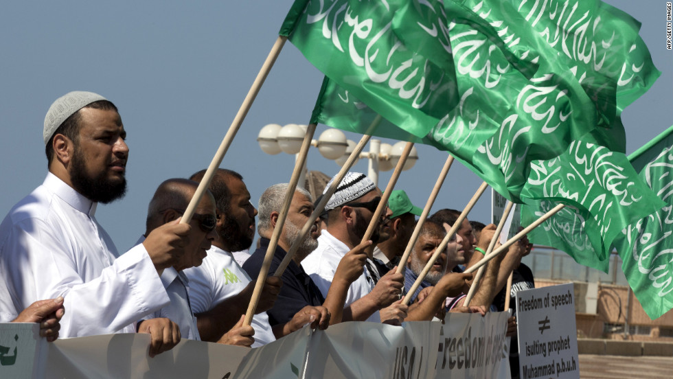 Arab-Israeli men wave green Islamic flags with the Muslim profession of belief: &quot;There is no God but God and Mohammed is the prophet of God&quot; during a protest in front of the U.S. Embassy on Thursday in Tel Aviv, Israel.