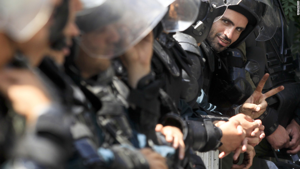 An Iranian police officer shows a victory sign during Thursday&#39;s demonstration in Tehran.