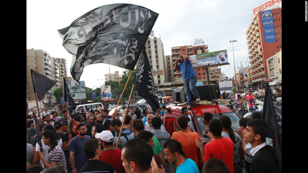 Protesters carry flags that read &quot;There is no God but Allah, Mohammed is Allah&#39;s messenger&quot; and chant during a protest in Tripoli, Lebanon, on Thursday.