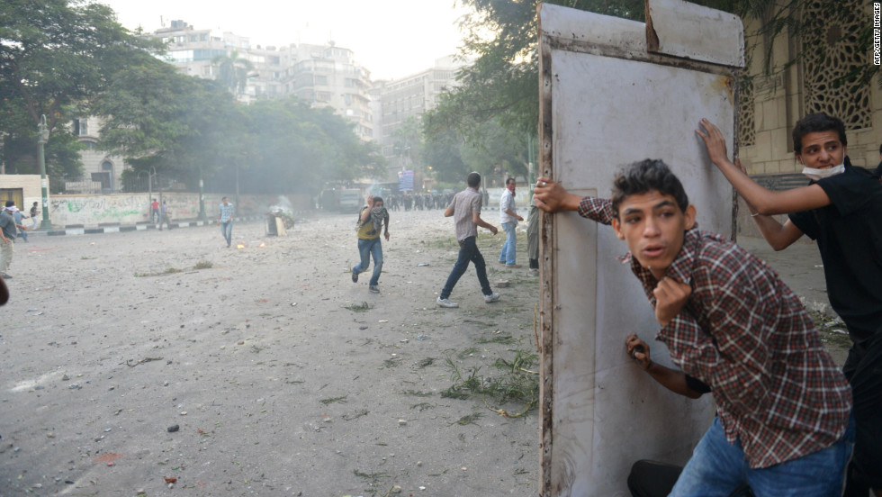 Egyptian protesters take cover during clashes with riot police on Thursday.