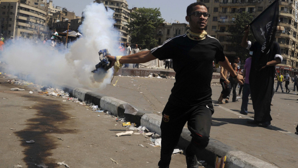 An Egyptian protester throws a tear gas canister toward riot police during clashes near the U.S. Embassy in Cairo on Friday.