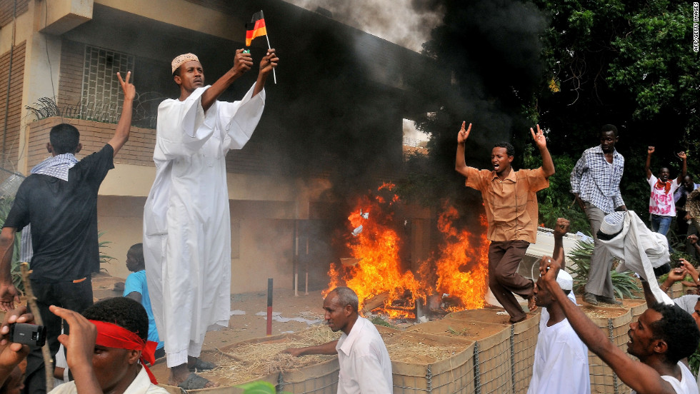 A Sudanese demonstrator burns a German flag after torching the German Embassy in Khartoum on Friday.