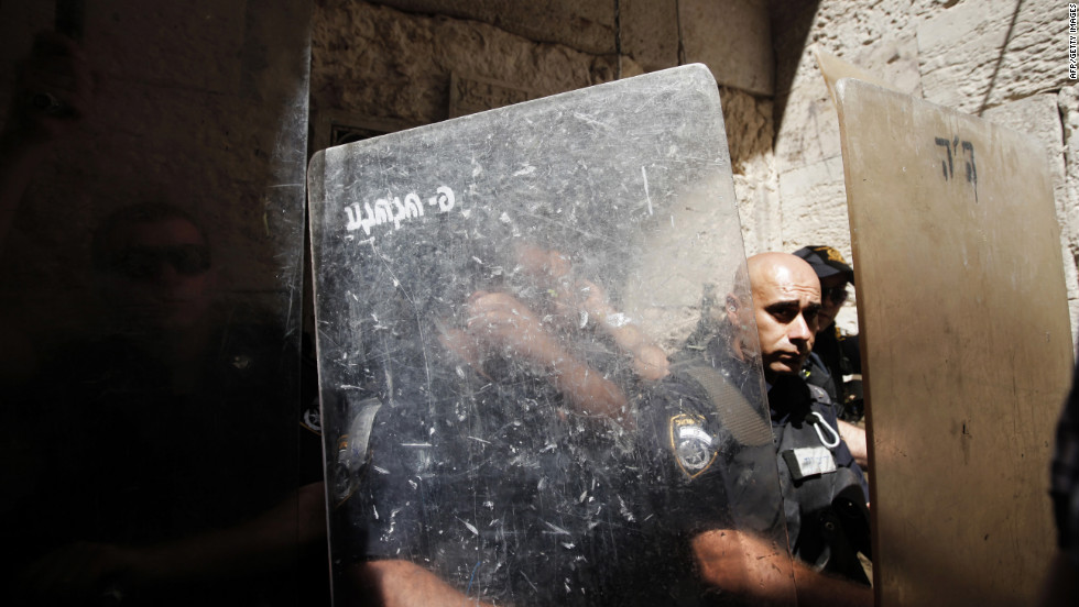 Israeli police officers stand behind their shields during clashes with stone-throwing Palestinian protesters in a demonstration against an anti-Islam film in front of the Dome of the Rock in Jerusalem&#39;s Old City on Friday.