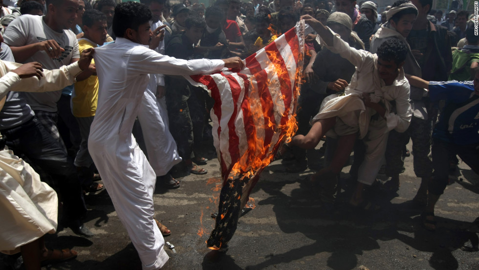 Yemeni protesters burn a U.S. flag on a street leading to the U.S. Embassy in Sanaa on Friday, September 14.