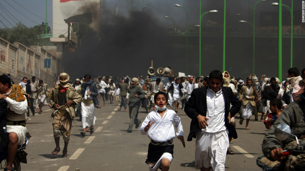 Yemeni protesters run for cover from tear gas fired by riot police in Sanaa on Friday.