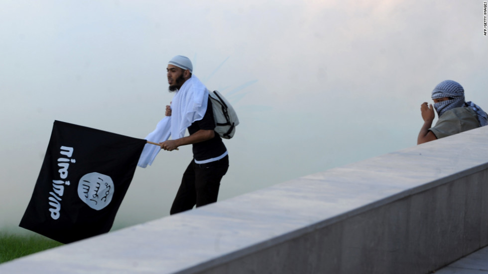 A Tunisian protester holds an Al-Qaeda affiliated flag amid the smoke coming from the tear gas fired by riot police outside the U.S. Embassy in Tunis on Friday.