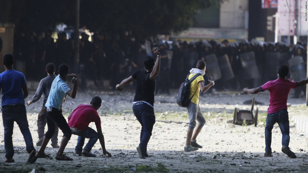 Protesters throw stones toward riot police during clashes along a road leading to the U.S. Embassy near Tahrir Square in Cairo on Friday, September 14.