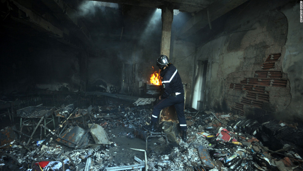 A Tunisian firefighter works inside a destroyed school building in the grounds of the American school in Tunis, Tunisia, on Saturday. Four people were killed and almost 50 injured in an attack on the U.S. Embassy in Tunis the day before by protesters angry over an anti-Islam film, the health ministry said. 