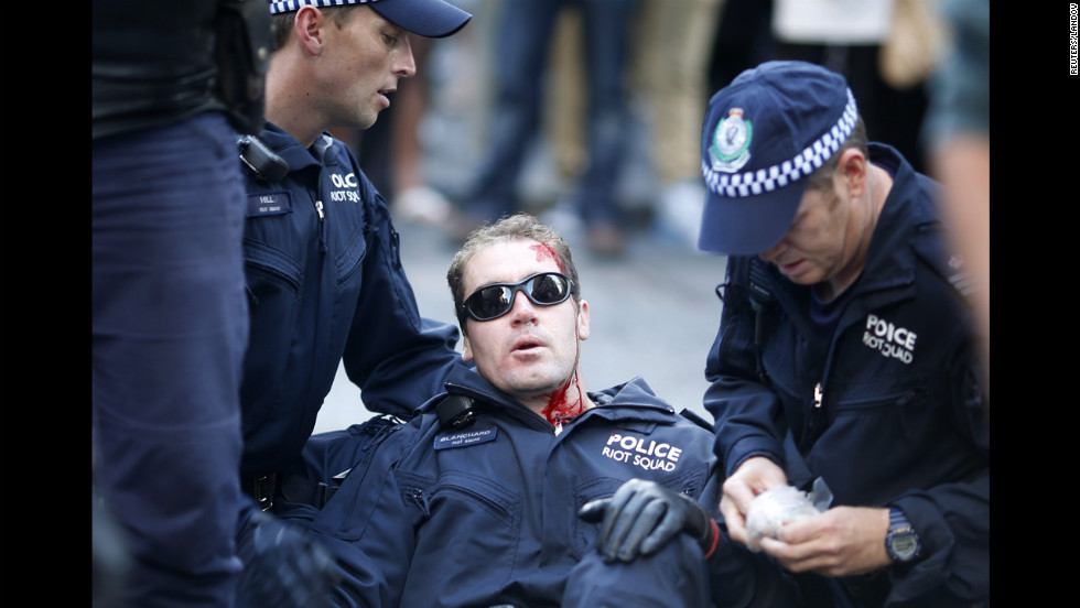  A policeman, injured by protesters, is assisted by colleagues in central Sydney on Saturday.