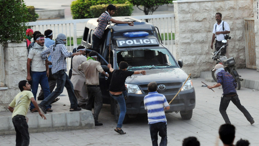 Protesters attack a police van outside the U.S. Consulate in Karachi on Sunday.