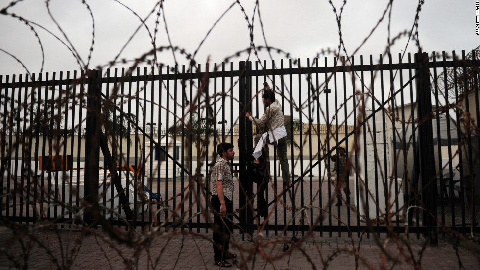 A protester climbs on a gate of the U.S. Consulate in Karachi, Pakistan, on Sunday.