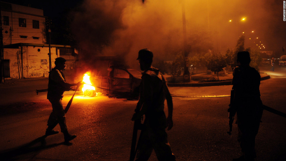 Pakistani paramilitary soldiers stand near a burning police van during an anti-U.S. protest organized by Pakistani Shiite Muslims in Karachi on Sunday.