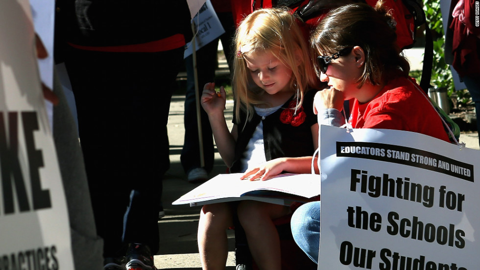 Teacher Jillian Connolly helps her daughter, Mary, study math while picketing outside of William H. Wells Community High School on Monday, September 10.