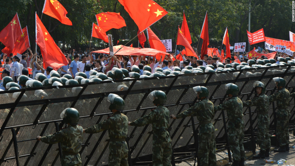 Chinese para-military police create a barrier to prevent protesters from breaching  the Japanese embassy in Beijing.