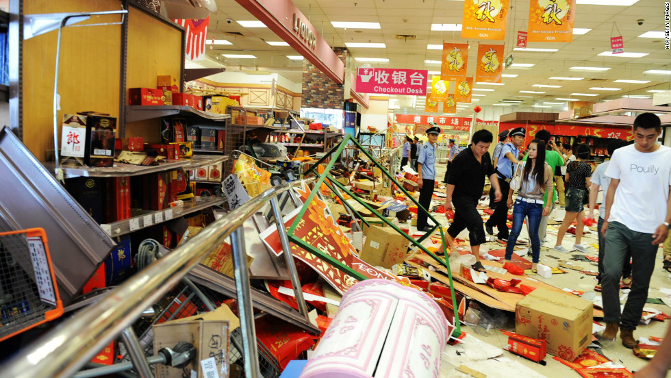 Security guards try to remove Chinese protesters who ransacked Japan&#39;s JUSCO departmental store, in Qingdao on September 15. 