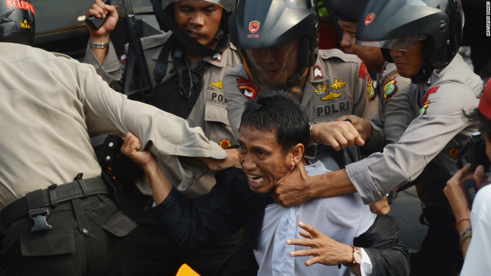 Indonesian anti-riot police arrest a protester Monday outside the U.S. Embassy in Jakarta. Monday&#39;s demonstrations come nearly a week after protests erupted in Egypt and Libya, spreading to more than 20 nations.