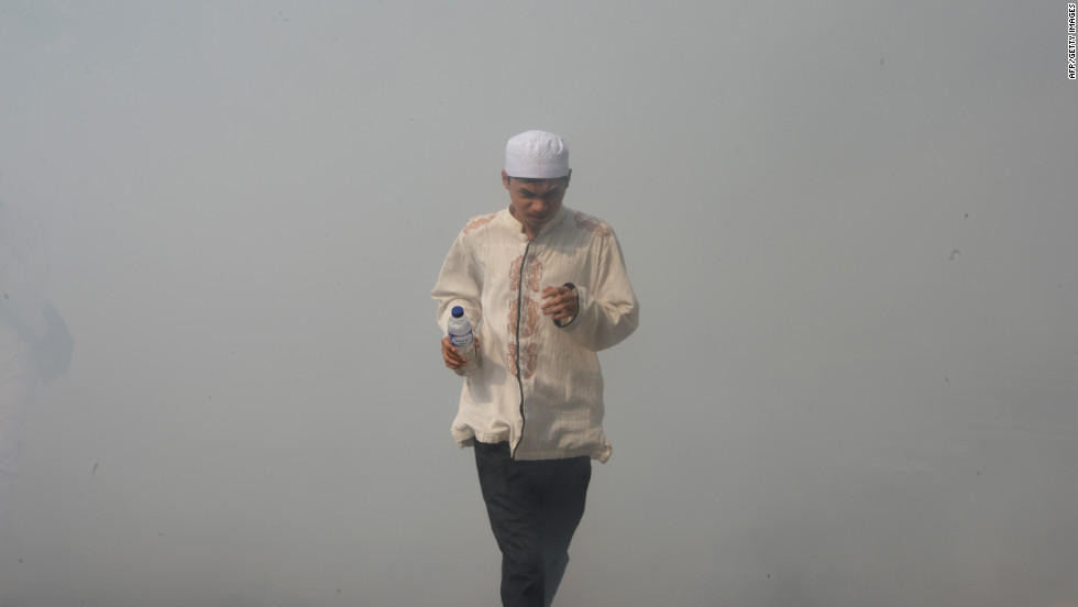 An Indonesian protester runs through smoke Monday outside the U.S. Embassy in Jakarta.