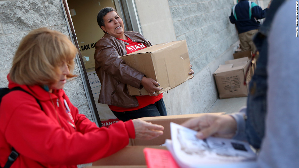 American Federation of Teachers organizer Samantha Jordan, center, carries a box of informational papers for distribution outside of protest locations in Chicago on Tuesday.