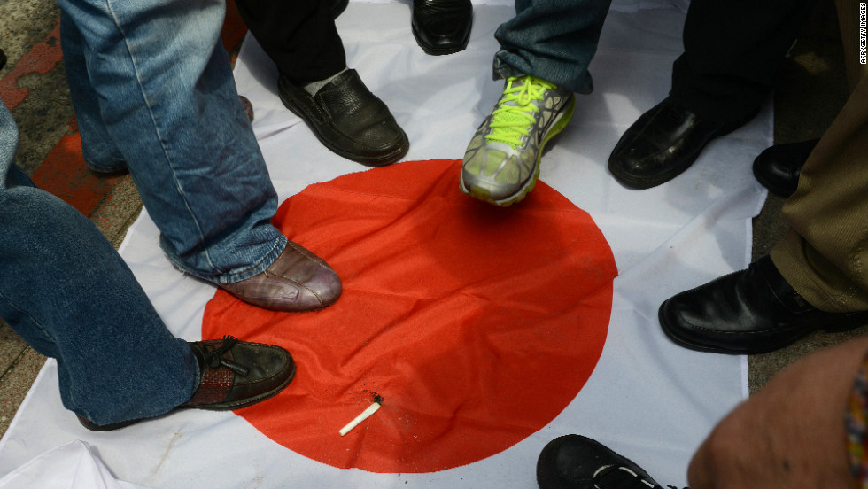 Anti-Japan activists step on a Japanese flag on September 18 during a protest in front of the parliament building in Taipei to demand the Taiwan government cooperate with China against Japan.