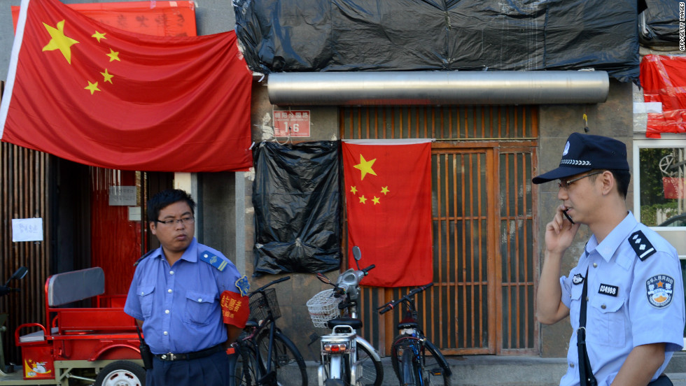 Police walk past a closed Japanese restaurant covered with Chinese national flags as anti-Japanese protests continued outside the Japanese Embassy in Beijing on September 17.