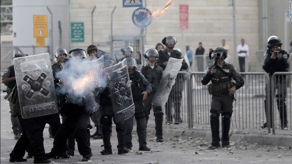 Israeli border policemen fire tear gas toward Palestinian protesters on Tuesday.