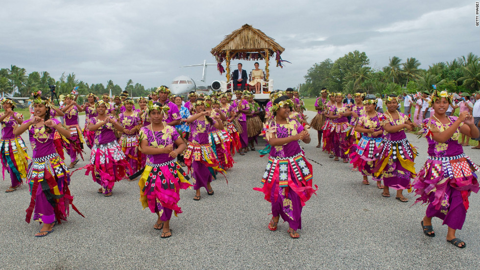 The royal couple are carried from their plane to a welcoming ceremony in Tuvalu on Tuesday. 