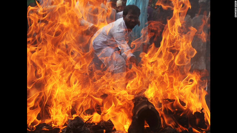 An Indian Muslim student hits a burning effigy of U.S. President Barack Obama during a protest in Kolkata on Wednesday.