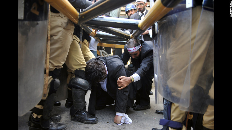 Police try to stop Pakistani lawyers crawling under a barrier as they try to reach the U.S. Embassy in the diplomatic enclave during a protest against an anti-Islam movie in Islamabad on Wednesday. 