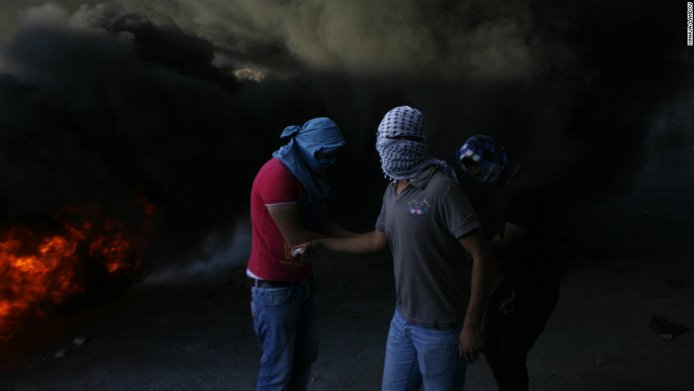 Masked Palestinians are seen during clashes with Israeli security forces in Shuafat refugee camp, Jerusalem, on Tuesday, September 18.