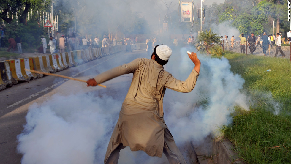 A Pakistani protester throws a tear gas shell back toward police on Thursday. 