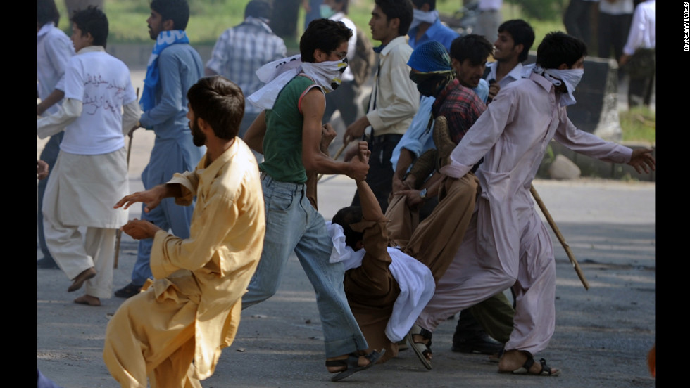 Pakistani demonstrators carry an injured person on Thursday.