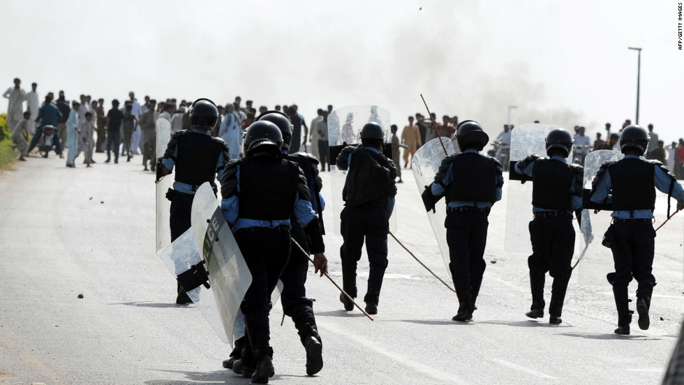 Pakistani riot police chase demonstrators Friday in Islamabad. 