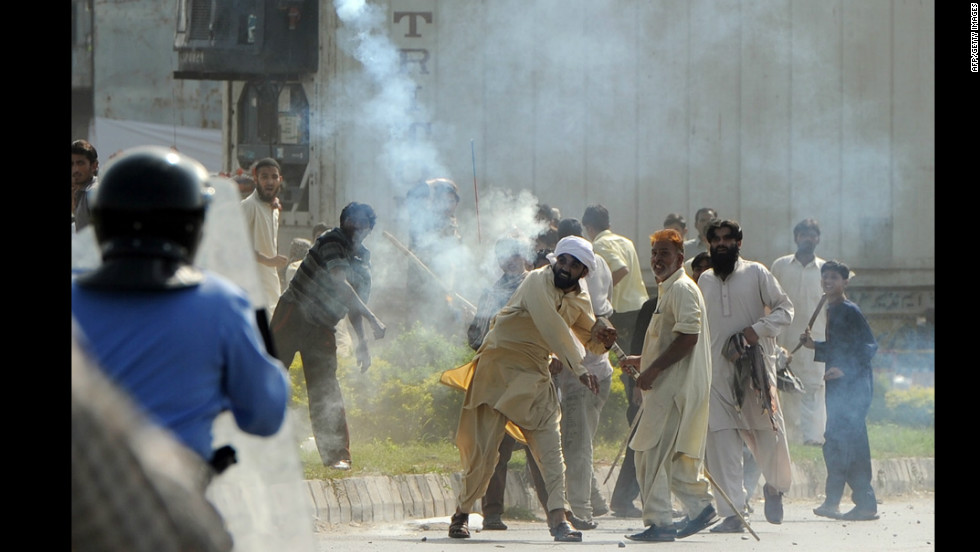 A Pakistani demonstrator throws a tear gas shell toward riot police during a protest against an anti-Islam film in Islamabad on Friday, September 21. Angry demonstrators set fire to two movie theaters in Pakistan&#39;s northwestern city of Peshawar as many braced for intensified protests Friday, officials said.