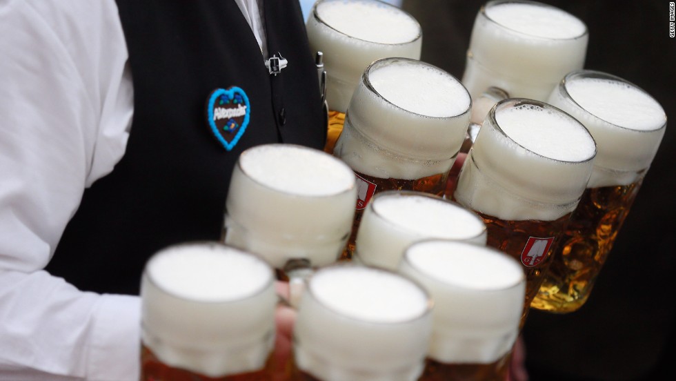 A waiter brings beer mugs to participants.