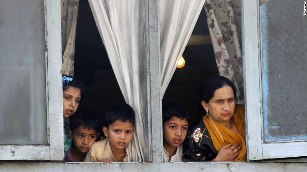 A family in Kashmir watches as students protest on Saturday.