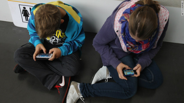 Children play video games on their smartphones. 