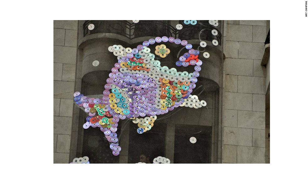 A giant fish made from CDs and and DVDs on the wall of a building in central Aleppo. They were collected by Art Camping participants in April. The fish remains in place despite heavy fighting in the area. &quot;I think both sides like it,&quot; said Touma.